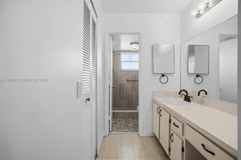 a bathroom with a double vanity sink a toilet and shower