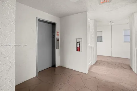 a view of a hallway with white walls and stairs