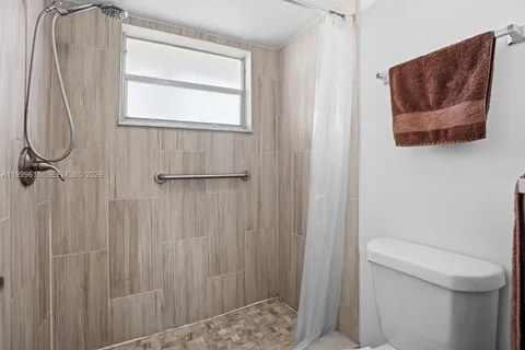 a bathroom with a toilet and a shower curtain