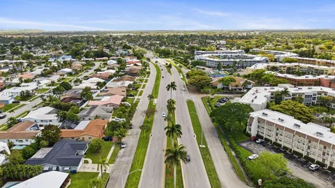 an aerial view of residential houses with outdoor space and trees