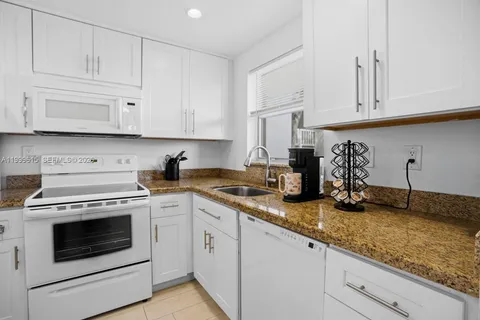 a kitchen with granite countertop cabinets stainless steel appliances and sink