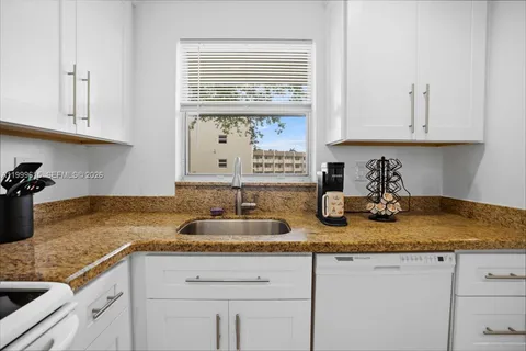 a kitchen with sink granite counter tops and a window
