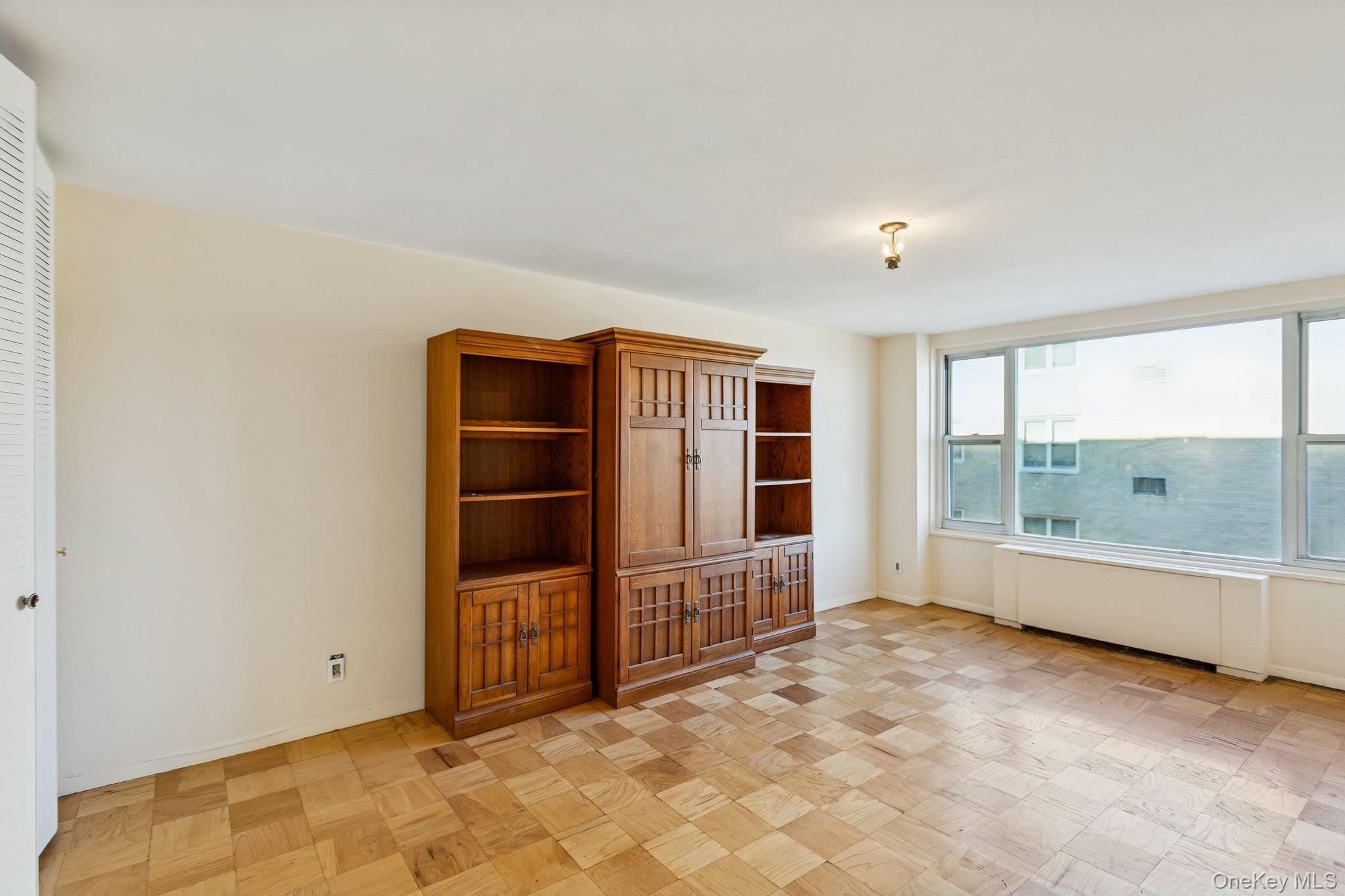 20 Old Mamaroneck Road, Unit 5Q White Plains, NY 10605 - Photo 11 of 18 an empty room with a large window and chandelier