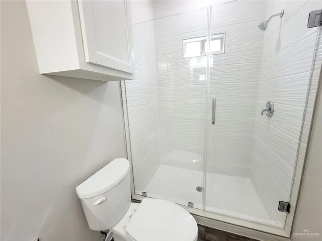 a bathroom with a toilet and a shower