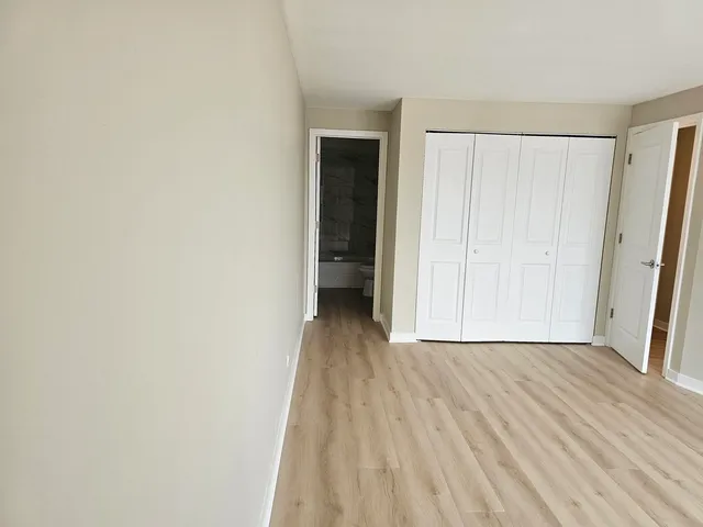 an empty room with wooden floor and a window