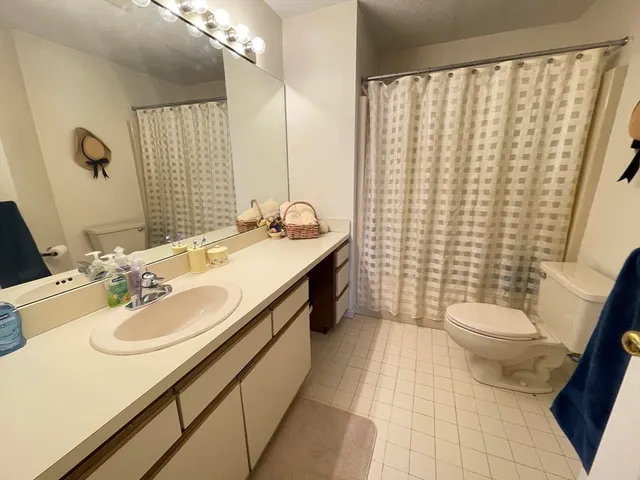 a view of a hallway with wooden floor and a bathroom