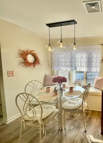 a kitchen with stainless steel appliances kitchen island granite countertop a refrigerator and a dining table