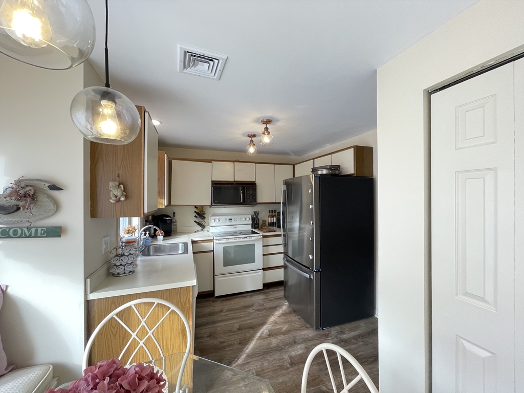 700 Shore Drive, Unit 6604 Fall River, MA 02721 - Photo 5 of 32 a kitchen with stainless steel appliances granite countertop a refrigerator a stove a sink dishwasher and a dining table with wooden floor