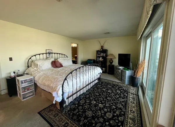 a bed sitting in a bedroom next to a window