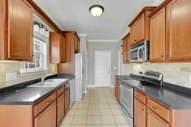 a kitchen with granite countertop a sink and a stove top oven