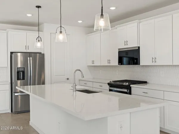 a kitchen with stainless steel appliances a refrigerator a sink and a stove