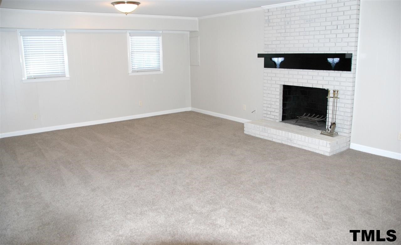2701 Wycliff Road Raleigh, NC 27607 - Photo 10 of 16 Oversized den on lower level features a wood burning fireplace with brick hearth and a wetbar. Den/Family/Great Room