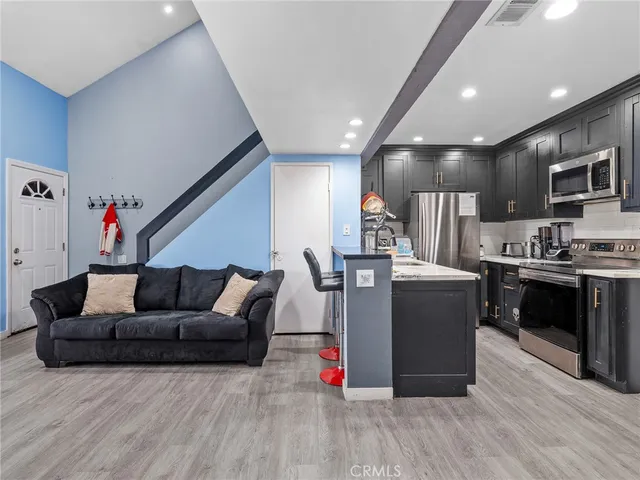 a living room with furniture and kitchen view