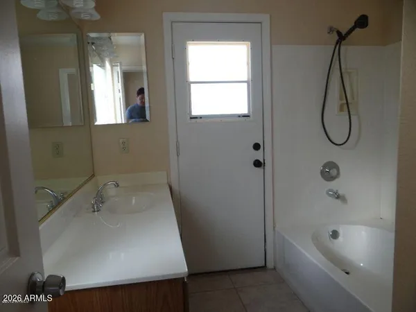 a bathroom with a sink a window and a shower