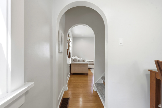 210 North 200 West Logan, UT 84321 - Photo 11 of 31 Arched doorways framing wood-finish flooring with baseboard trim and white walls