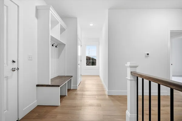 a view of a hallway with wooden floor and staircase