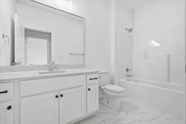 a bathroom with a sink a toilet a mirror and shower