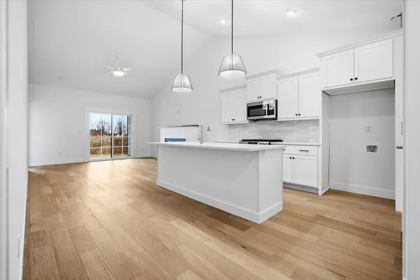 a kitchen with kitchen island white cabinets and stainless steel appliances