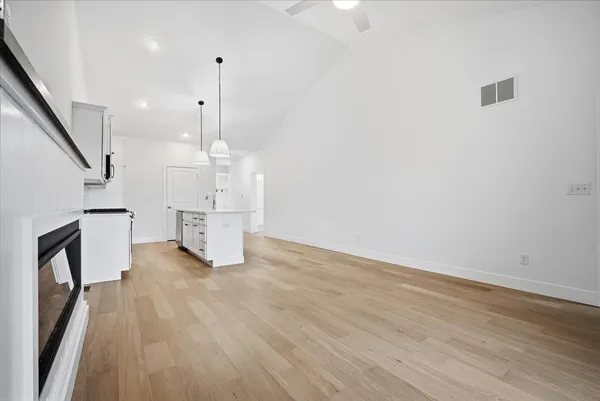 a view of empty room with wooden floor and fireplace