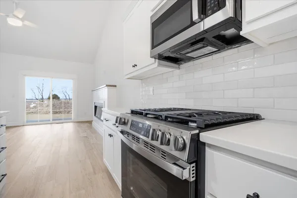 a kitchen with granite countertop a stove and a wooden floors