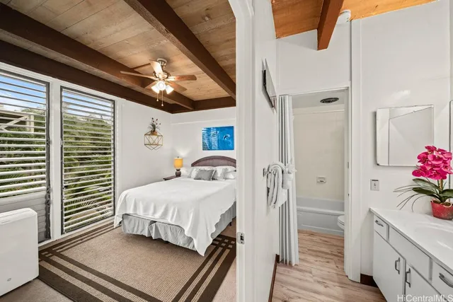 a bedroom with a bed and a dresser with wooden floor