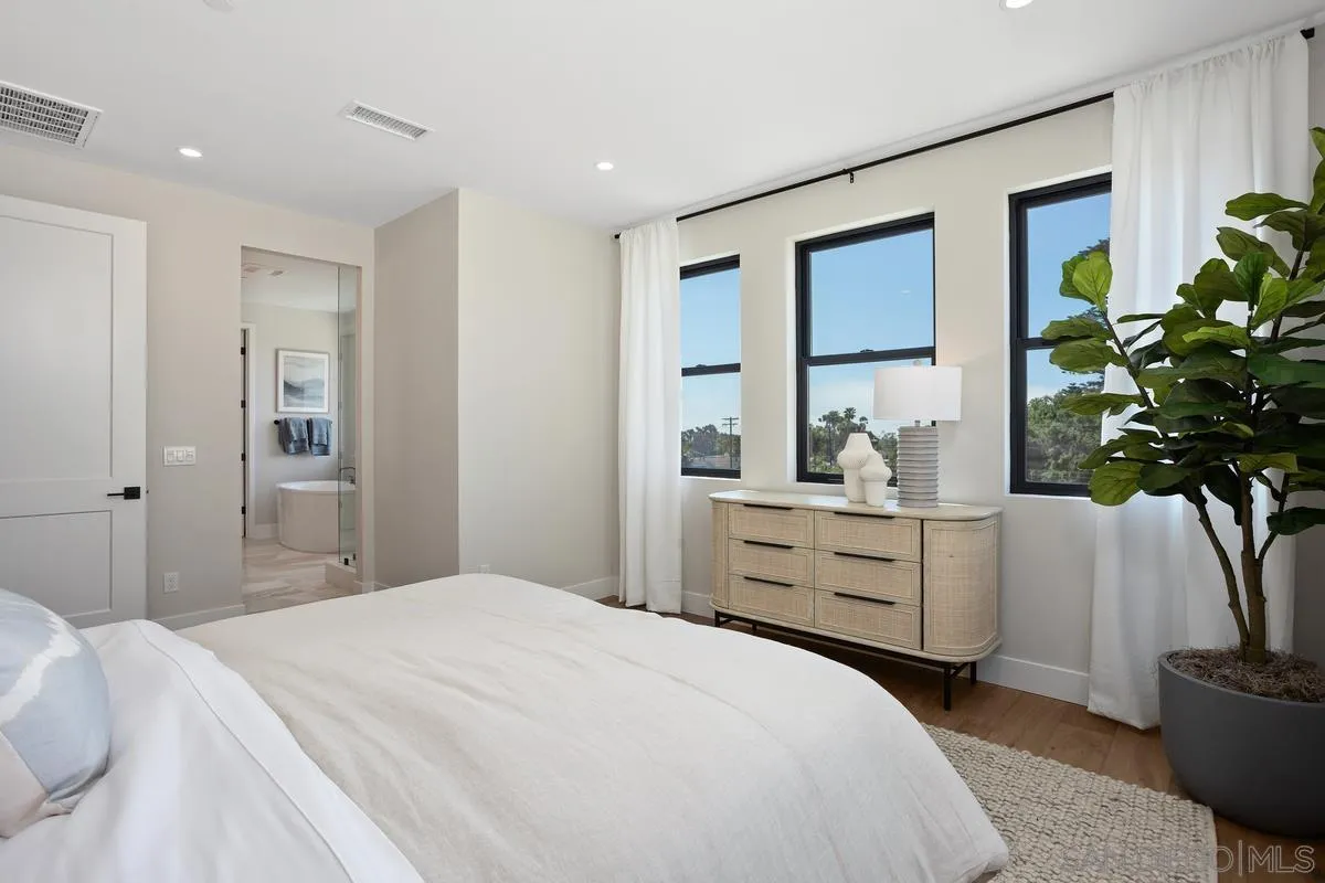 1748 Whaley Street Oceanside, CA 92054 - Photo 22 of 38 a bedroom with a large bed and a potted plant