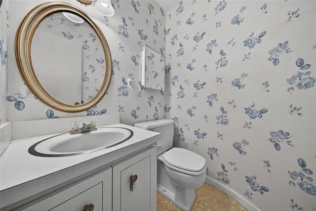a bathroom with a granite countertop toilet sink and mirror