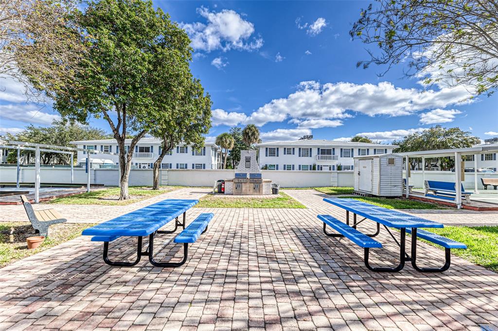 2220 Northeast 68th Street, Unit 1005 Fort Lauderdale, FL 33308 - Photo 19 of 25 a swimming pool with outdoor seating and yard