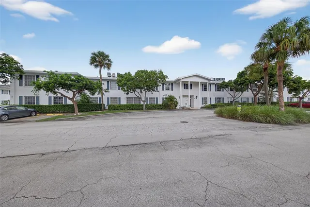 a view of a house with a yard and large trees