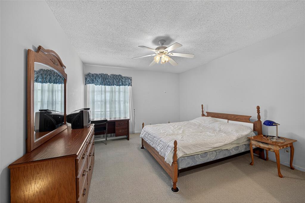 2220 Northeast 68th Street, Unit 1005 Fort Lauderdale, FL 33308 - Photo 9 of 25 a bedroom with a bed and a chandelier