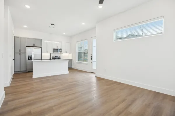 a view of a kitchen with a sink a refrigerator and window