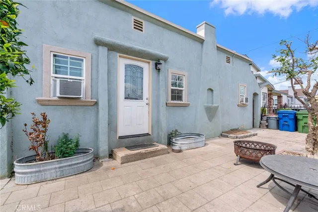 a view of a patio with couches table and chairs and potted plants