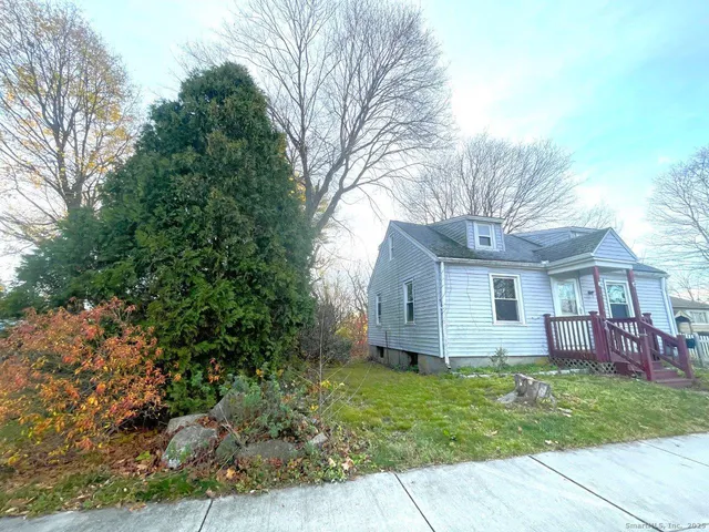 a front view of house with yard and trees around