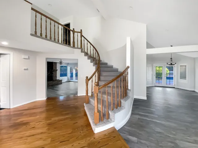 a view of staircase with white walls and wooden floor