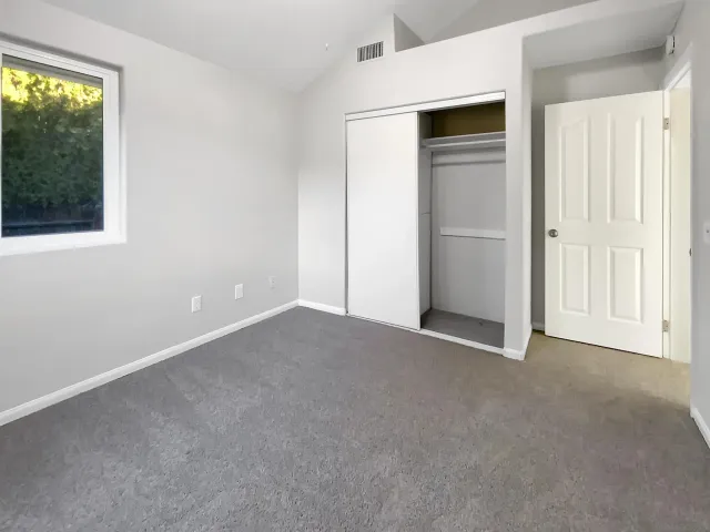 an empty room with windows and closet