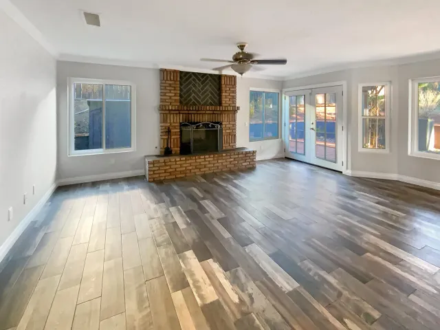 a view of empty room with wooden floor and fireplace