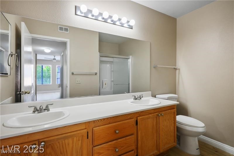 1575 West Warm Springs Road, Unit 2122 Henderson, NV 89014 - Photo 18 of 24 Bathroom with double vanity, a stall shower, dark wood-style flooring, and a ceiling fan