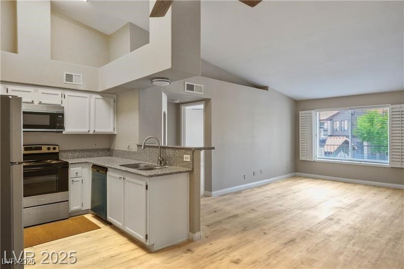 1575 West Warm Springs Road, Unit 2122 Henderson, NV 89014 - Photo 10 of 24 Kitchen featuring stainless steel appliances, white cabinets, light wood-style floors, lofted ceiling, and a ceiling fan