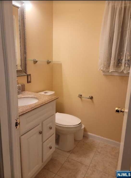 110 Church Street, Unit 1 Lodi, NJ 07644 - Photo 6 of 7 a bathroom with a toilet a sink and a mirror