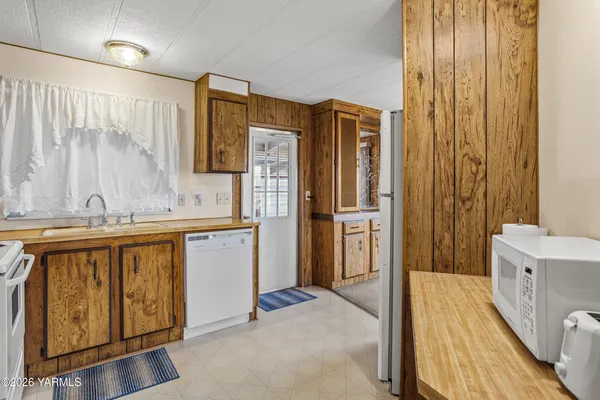 a bathroom with a granite countertop sink a mirror a bathtub and shower