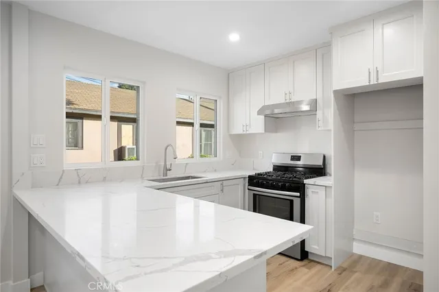 a kitchen with granite countertop a stove and a sink