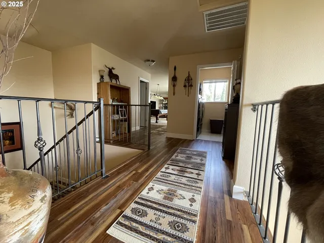 a view of a hallway with wooden floor and staircase
