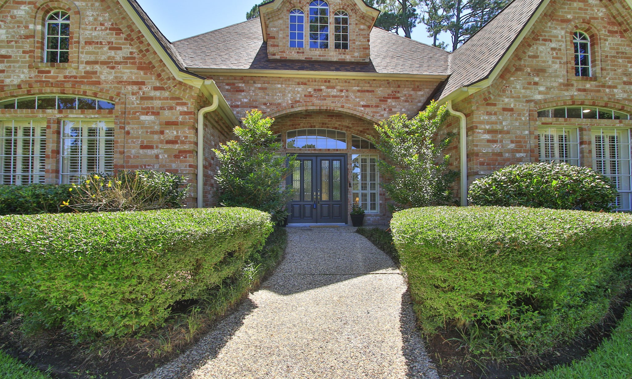 15923 Harwick Drive Spring, TX 77379 - Photo 4 of 50 Lush landscaping frames the entrance to the double lead glass front doors.