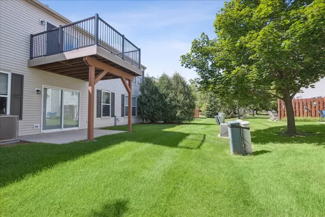 a view of a house with backyard and a tree