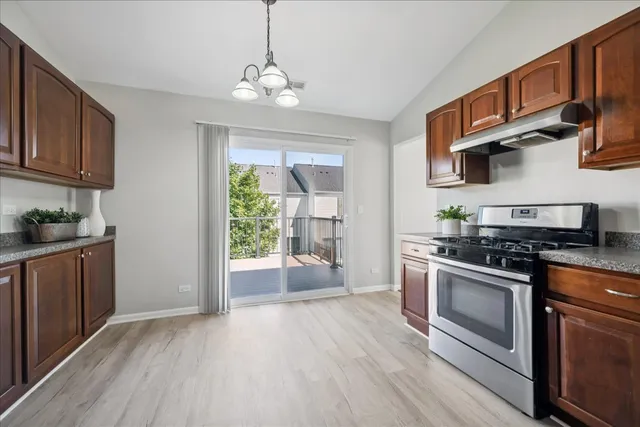 a kitchen with stainless steel appliances granite countertop a stove and cabinets
