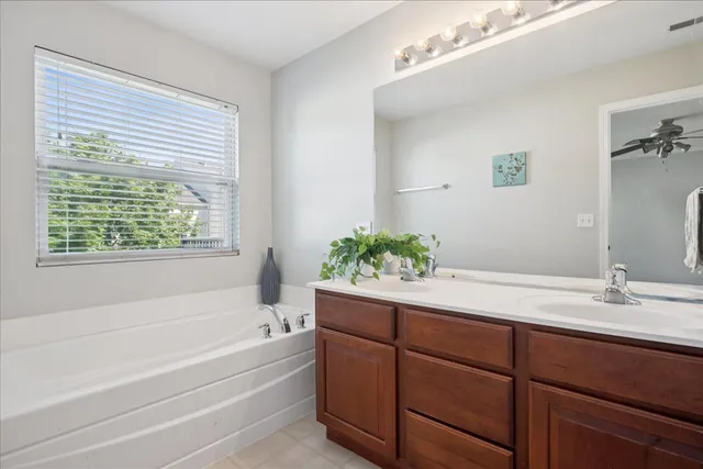 a bathroom with a tub sink and mirror
