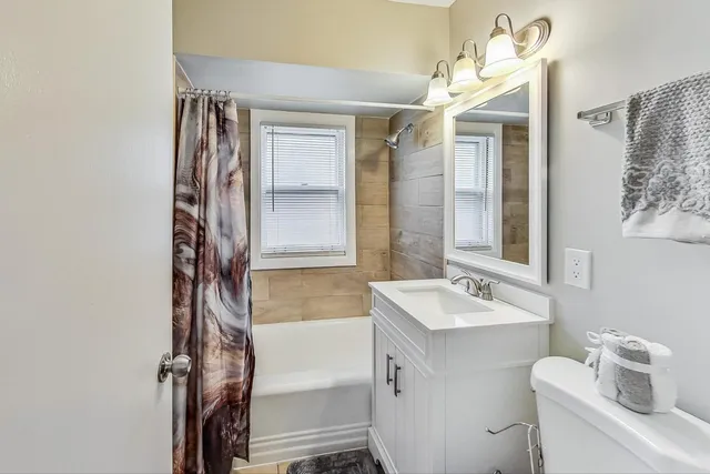 a bathroom with a sink mirror vanity and toilet
