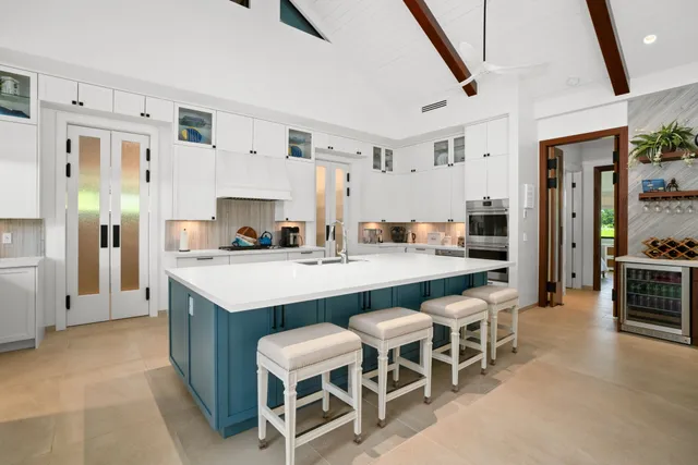 a kitchen with stainless steel appliances kitchen island granite countertop a table chairs and a refrigerator