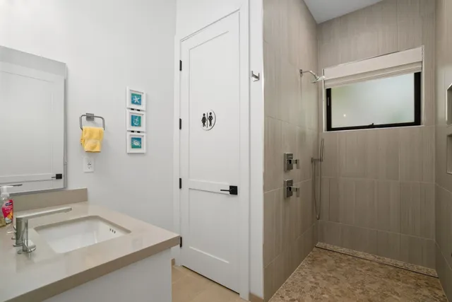 a bathroom with a sink and mirror with toilet