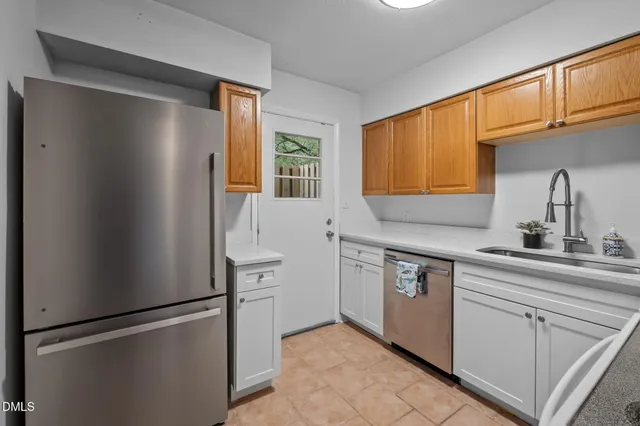 a kitchen with stainless steel appliances granite countertop a refrigerator and a sink